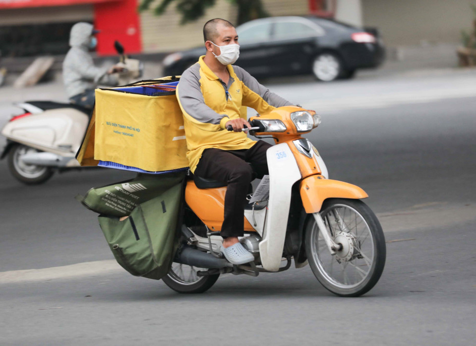 Nhân viên giao hàng không đội mũ bảo hiểm. (Ảnh: Thanh Tùng/TTXVN)