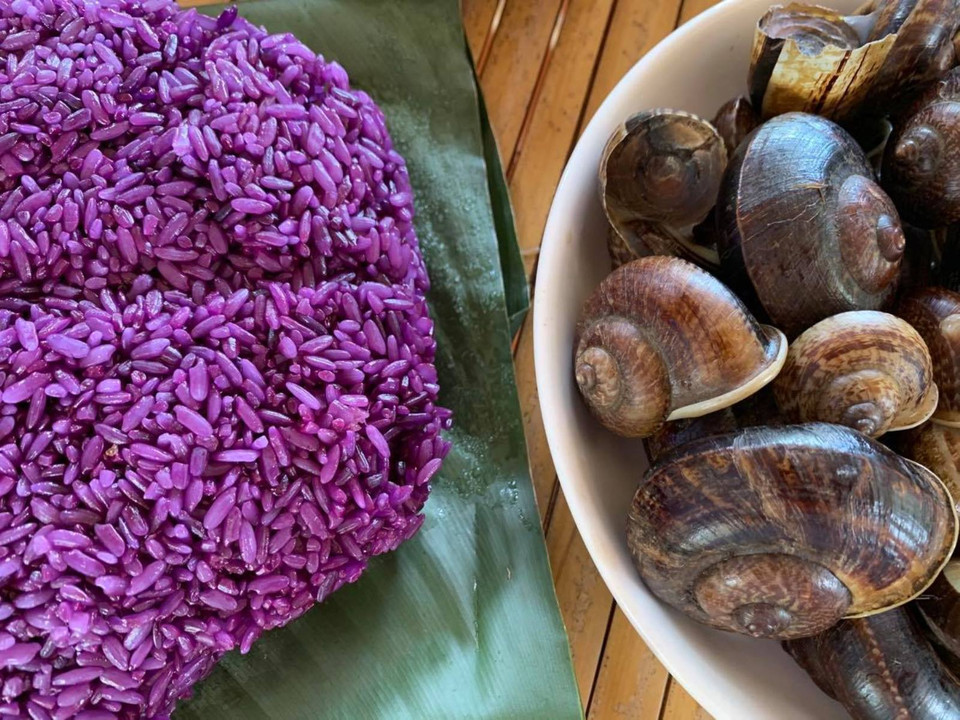 Xôi tím được nhuộm màu từ lá cây Khẩu Căm của người Thái ở Sơn La và ốc đá. (Ảnh: Vietnam+)