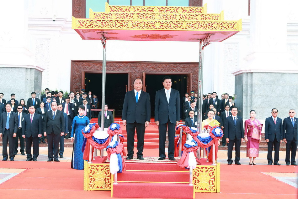 Thủ tướng Nguyễn Xuân Phúc và Thủ tướng Lào Thongloun Sisoulith chào cờ. (Ảnh: Thống Nhất/TTXVN)