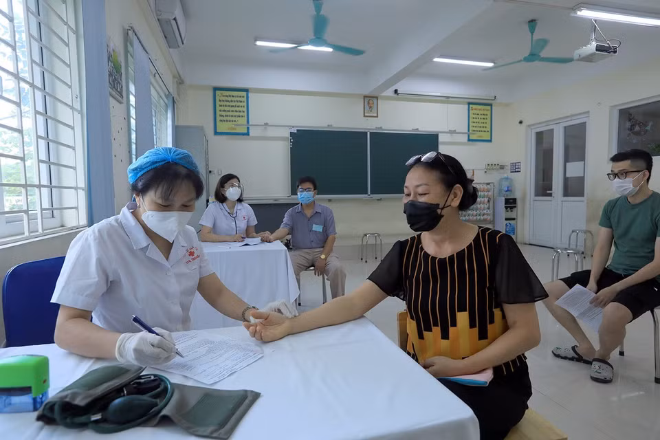 Nhân viên y tế phường Kim Giang khám sàng lọc cho người dân trước khi tiêm. (Ảnh: Phan Tuấn Anh/TTXVN)
