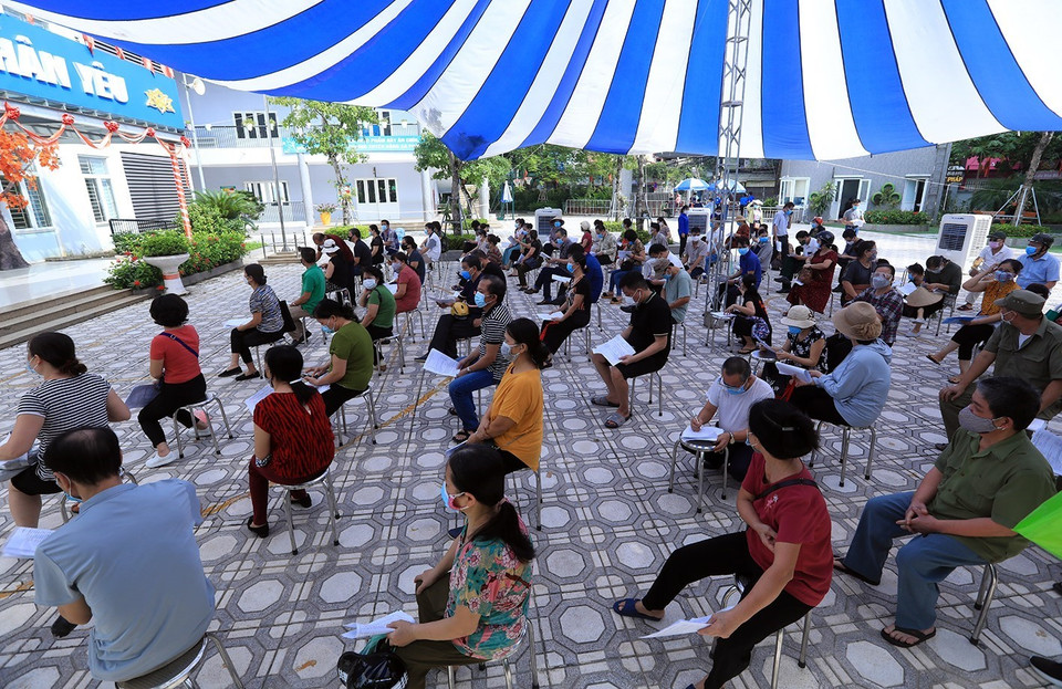 Người dân đến tiêm phải tuân thủ đảm bảo giãn cách an toàn phòng tránh dịch COVID-19. (Ảnh: Phan Tuấn Anh/TTXVN)