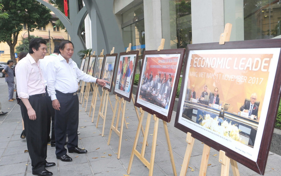 Bộ trưởng Bộ Thông tin và Truyền thông Trương Minh Tuấn và cán bộ, phóng viên TTXVN tham quan trưng bày ảnh Tuần lễ Cấp cao APEC 2017. (Ảnh: Doãn Tấn/TTXVN)