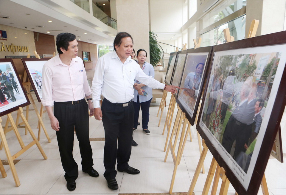 Bộ trưởng Bộ Thông tin và Truyền thông Trương Minh Tuấn và cán bộ, phóng viên TTXVN tham quan trưng bày ảnh Tuần lễ Cấp cao APEC 2017. (Ảnh: Doãn Tấn/TTXVN)