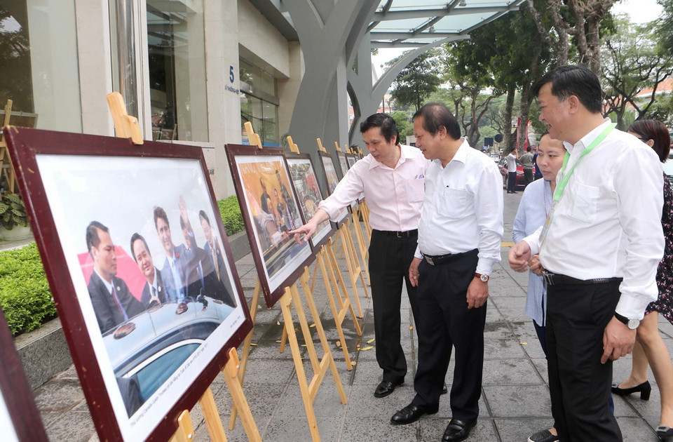 Bộ trưởng Bộ Thông tin và Truyền thông Trương Minh Tuấn và cán bộ, phóng viên TTXVN tham quan trưng bày ảnh Tuần lễ Cấp cao APEC 2017. (Ảnh: Doãn Tấn/TTXVN)