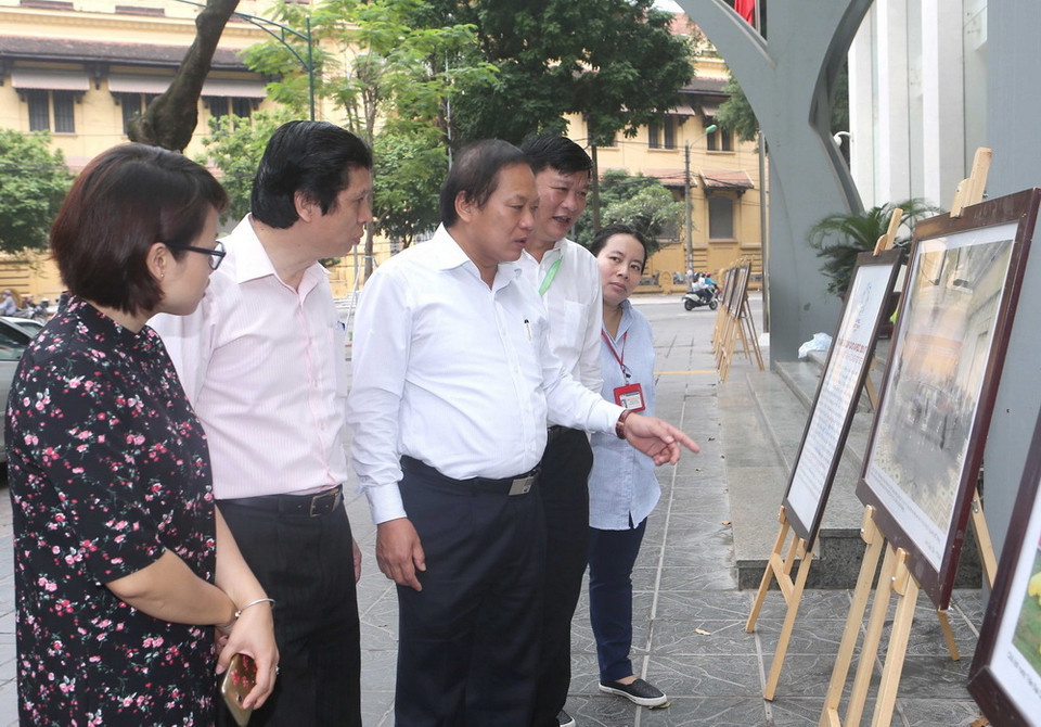 Bộ trưởng Bộ Thông tin và Truyền thông Trương Minh Tuấn và cán bộ, phóng viên TTXVN tham quan trưng bày ảnh Tuần lễ Cấp cao APEC 2017. (Ảnh: Doãn Tấn/TTXVN)