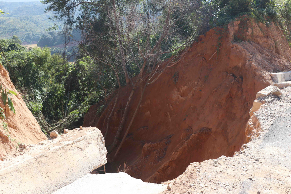 Một đoạn vách taluy âm với khối lượng lớn đất, cây cối đã trượt xuống chân núi làm hư hỏng hệ thống thoát nước và một phần của làn đường. (Ảnh: Xuân Tiến/TTXVN)