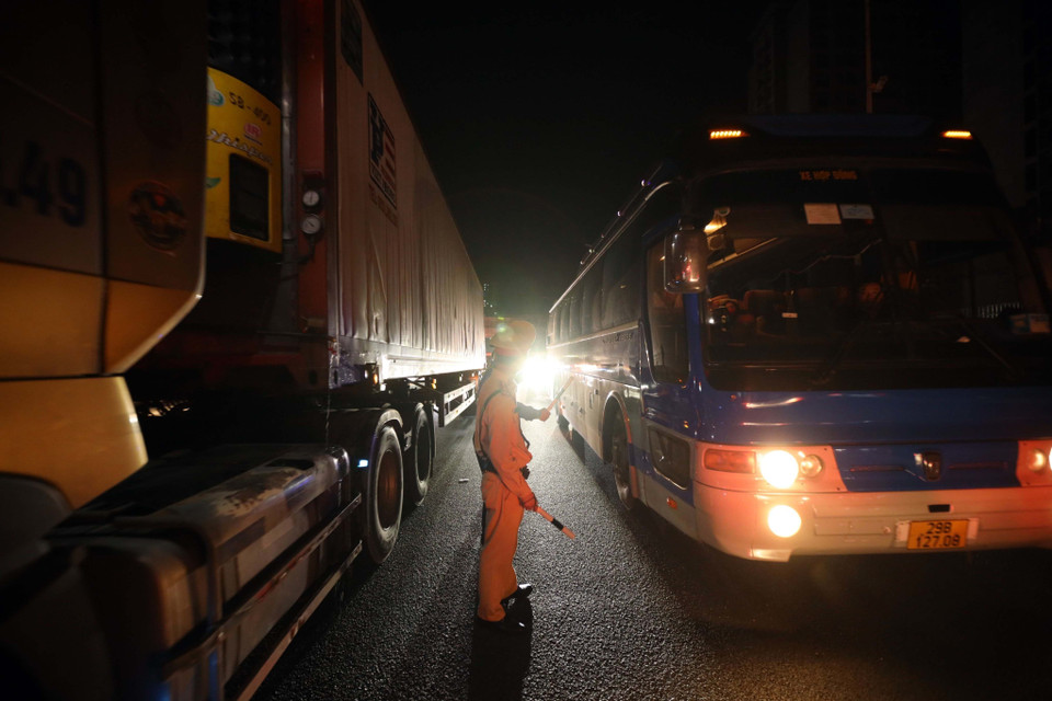 Lực lượng cảnh sát giao thông ứng trực điều tiết, phân luồng giao thông trong đêm tại cao tốc Pháp Vân-Cầu Giẽ. (Ảnh: Phạm Kiên/TTXVN)