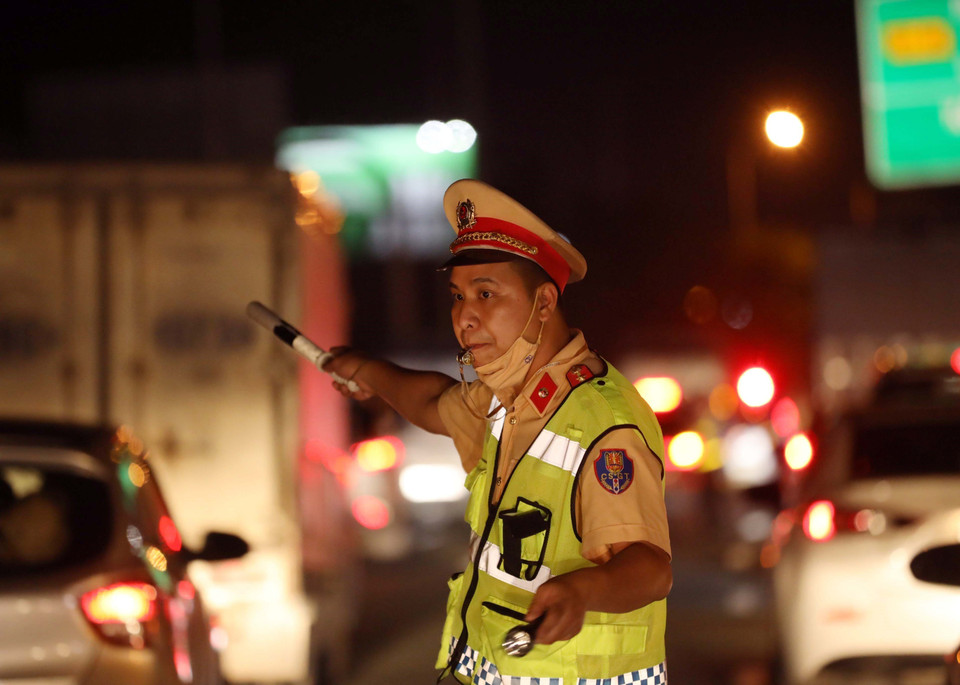 Lực lượng cảnh sát giao thông ứng trực điều tiết, phân luồng giao thông trong đêm tại cao tốc Pháp Vân-Cầu Giẽ. (Ảnh: Phạm Kiên/TTXVN)