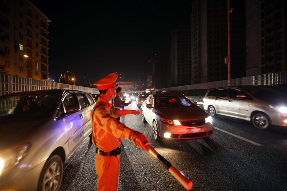 Lực lượng cảnh sát giao thông điều tiết, phân luồng giao thông trong đêm tại cao tốc Pháp Vân-Cầu Giẽ. (Ảnh: Phạm Kiên/TTXVN)