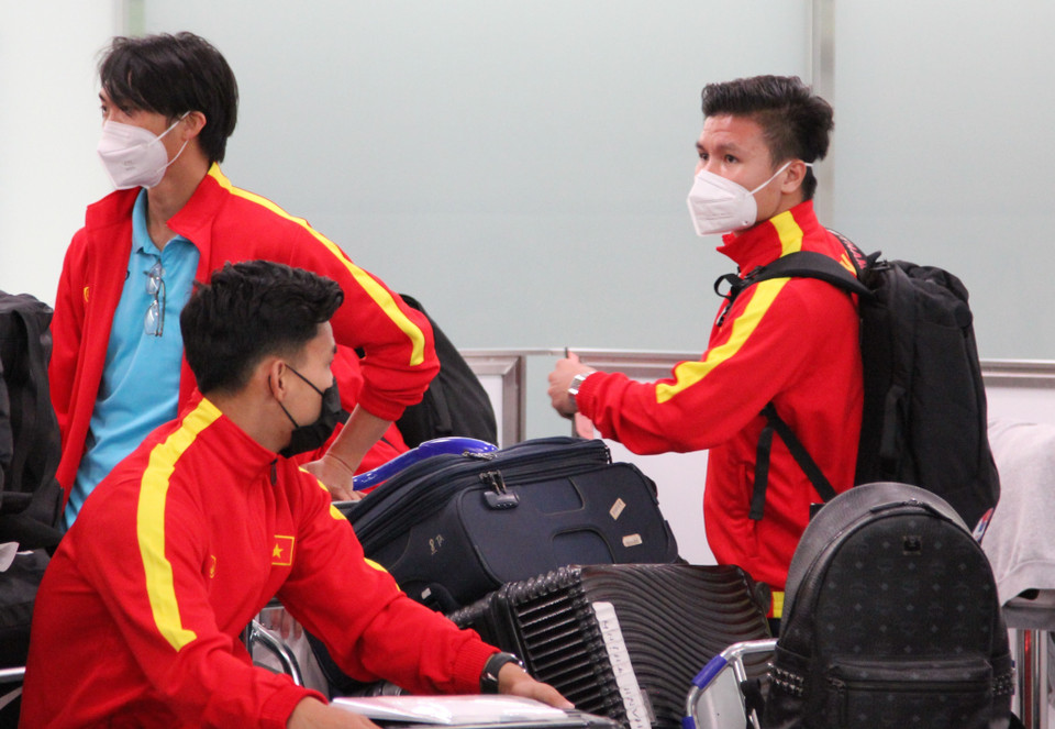 Các tiền vệ Quang Hải và Tuấn Anh đang chờ lên xe buýt ở sân bay. (Ảnh: Đào Thanh Tùng/TTXVN)