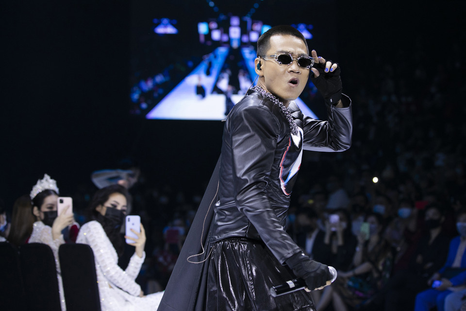 Thể hiện ca khúc 'Cứu công chúa,' Wowy cho biết ca khúc anh chưa từng công bố này được lên ý tưởng từ game Mario diệt rồng cứu công chúa và mang cảm hứng âm nhạc của nghìn lẻ một đêm. Anh chàng diện set đồ với tông đen, được xử lý chần bông, pha phối nhiều chất liệu có sự trái ngược về chất liệu: bóng, thô, mềm, cứng. (Ảnh: CTV/Vietnam+)