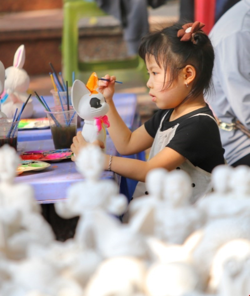 Em nhỏ tô tượng trên phố Đinh Lễ. (Ảnh: Tuấn Đức/TTXVN)