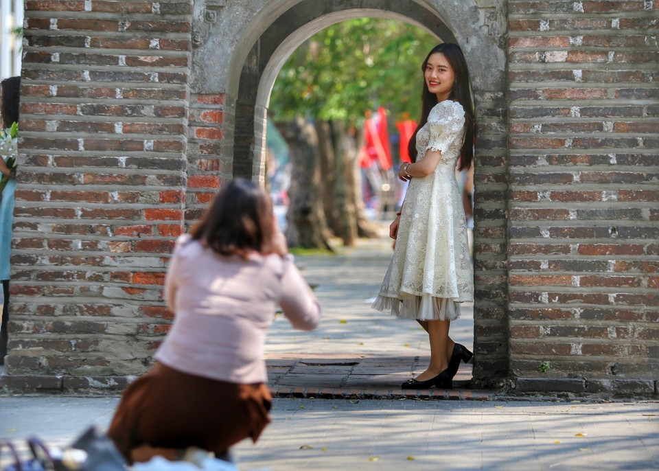 Các bạn trẻ chụp ảnh lưu niệm tại ven Hồ Gươm. (Ảnh: Tuấn Đức/TTXVN)