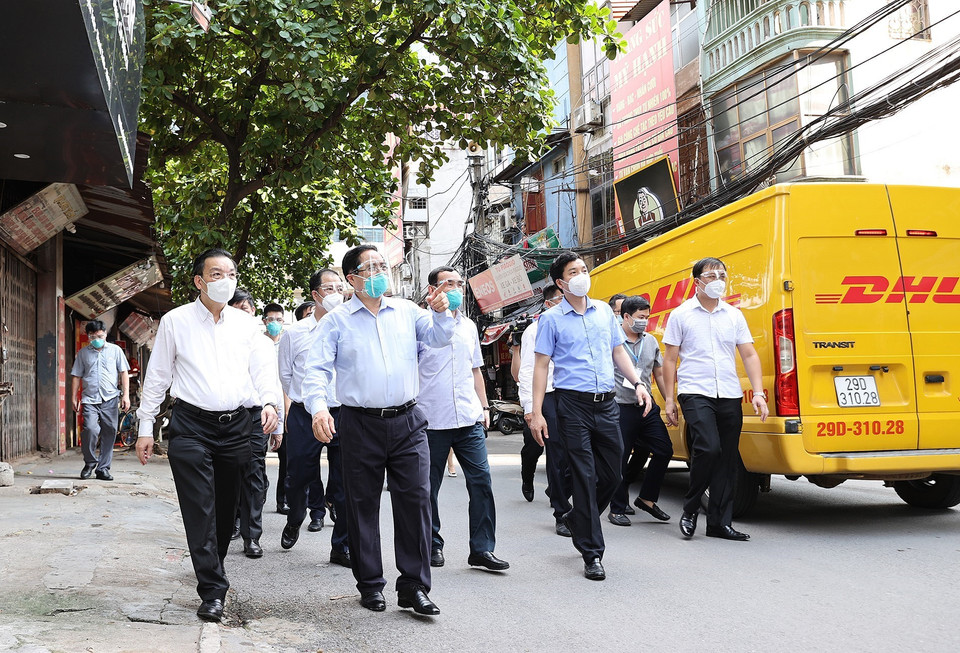 Thủ tướng Phạm Minh Chính và đoàn công tác đi kiểm tra đột xuất công tác phòng, chống dịch ở một số điểm nóng về dịch bệnh COVID-19 tại Hà Nội. (Ảnh: Dương Giang/TTXVN)