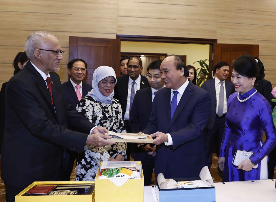 Chủ tịch nước Nguyễn Xuân Phúc và Phu nhân với Tổng thống Singapore Halimah Yacob và Phu quân Mohamed Bin Abdullah Alhabshee trao đổi tặng phẩm. (Ảnh: Thống Nhất/TTXVN)