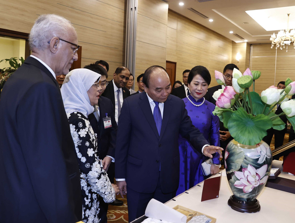 Chủ tịch nước Nguyễn Xuân Phúc và Phu nhân với Tổng thống Singapore Halimah Yacob và Phu quân Mohamed Bin Abdullah Alhabshee trao đổi tặng phẩm. (Ảnh: Thống Nhất/TTXVN)