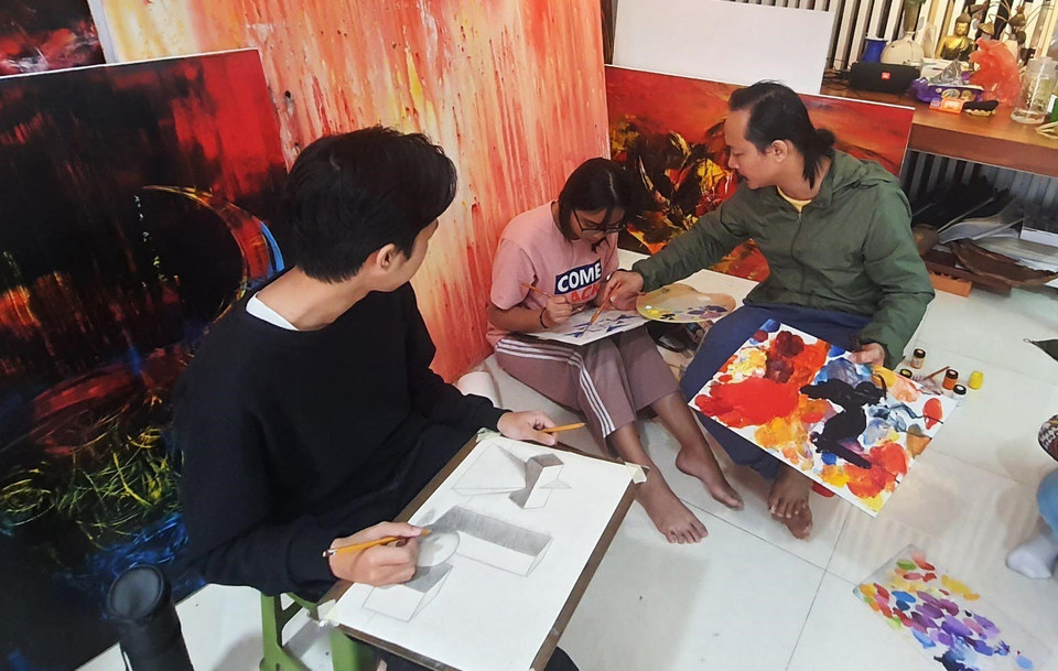 Họa sỹ Ngô Thanh Hùng dạy học sinh vẽ tại nhà. (Ảnh: Văn Dũng/TTXVN)