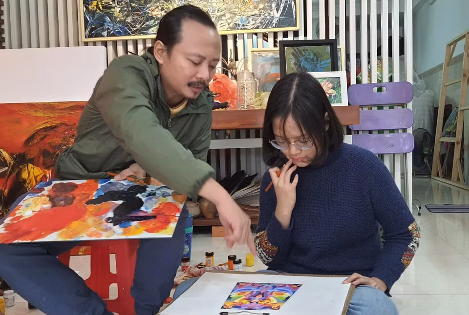Họa sỹ Ngô Thanh Hùng dạy học sinh vẽ tại nhà. (Ảnh: Văn Dũng/TTXVN)
