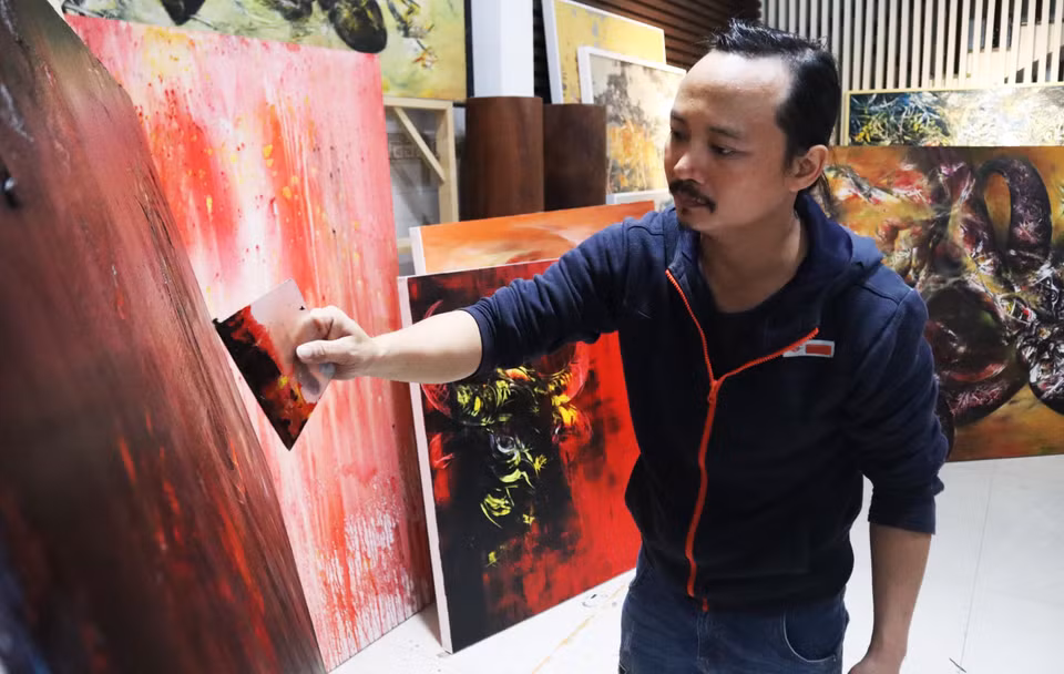 Họa sĩ Ngô Thanh Hùng sáng tác tranh tại nhà. (Ảnh: Văn Dũng/TTXVN)