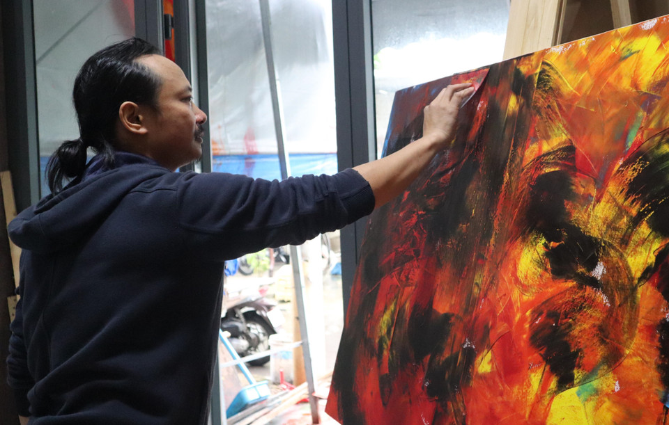 Họa sỹ Ngô Thanh Hùng sáng tác tranh tại nhà. (Ảnh: Văn Dũng/TTXVN)