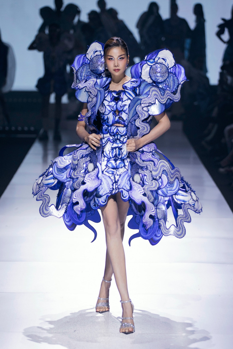 Chưa hết bất ngờ, siêu mẫu Thanh Hằng xuất hiện tỏa sáng trong vị trí vedette giữa dàn mẫu càng tăng thêm cảm xúc thăng hoa cho đêm diễn. Với phong thái quyền lực, “chị đại làng mẫu” Thanh Hằng đã thể hiện sự kiêu hãnh thông qua bộ cánh lộng lẫy, “phát sáng” giữa màn đêm tựa những gợn sóng lấp lánh dưới mặt hồ tĩnh lặng. (Ảnh: CTV/Vietnam+)