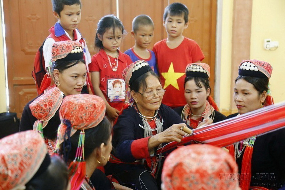 Phụ nữ cao tuổi truyền nghề dệt thổ cẩm đồng bào Dao (Thanh Y) cho thế hệ trẻ thôn Éo, xã Phúc Ninh, huyện Yên Sơn (Tuyên Quang). (Ảnh: Nam Sương/TTXVN)