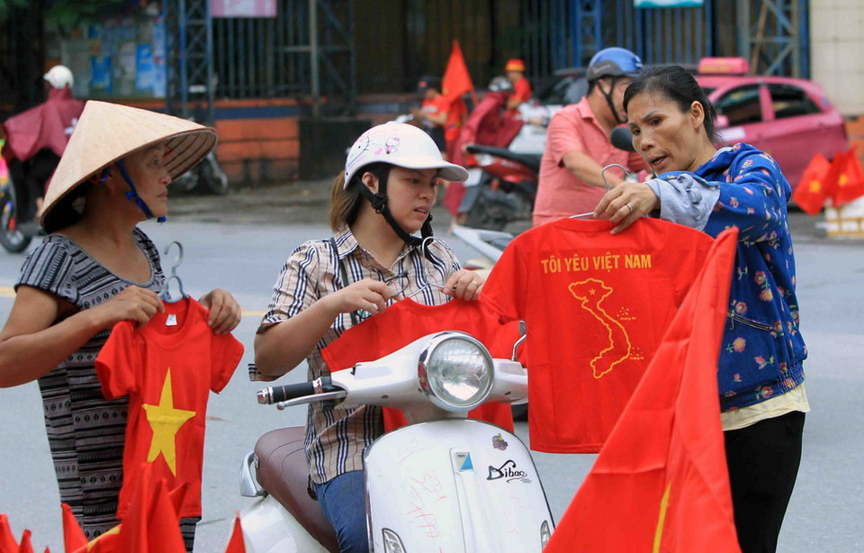 Cổ động viên tại Hải Phòng mua áo đỏ cổ vũ cho đội tuyển Olympic Việt Nam tại sân vận động Lạch Tray. (Ảnh: An Đăng/TTXVN)