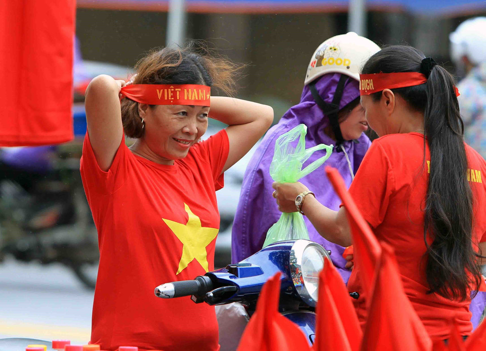 Cổ động viên tại TP Hải Phòng mua băng rôn chuẩn bị cổ vũ cho đội tuyển Olympic Việt Nam tại sân vận động Lạch Tray. (Ảnh: An Đăng/TTXVN)