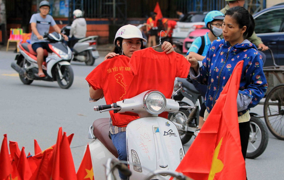 Cổ động viên tại Hải Phòng mua áo đỏ cổ vũ cho đội tuyển Olympic Việt Nam tại sân vận động Lạch Tray. (Ảnh: An Đăng/TTXVN)