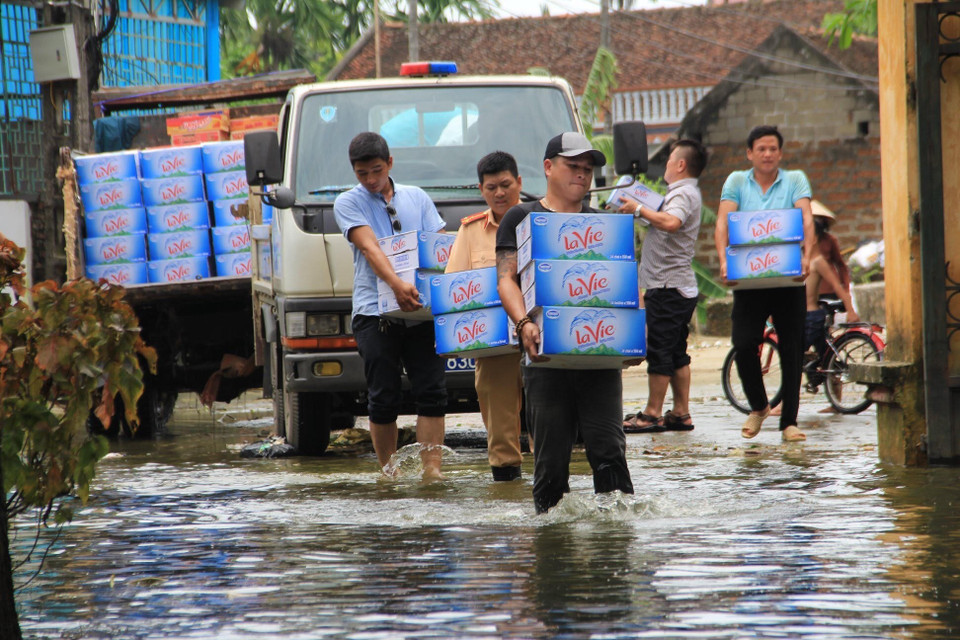 Các nhà hảo tâm, tình nguyện viên liên tục hỗ trợ nước uống, lương thực cho người dân. (Ảnh: Nguyễn Văn Cảnh/TTXVN)