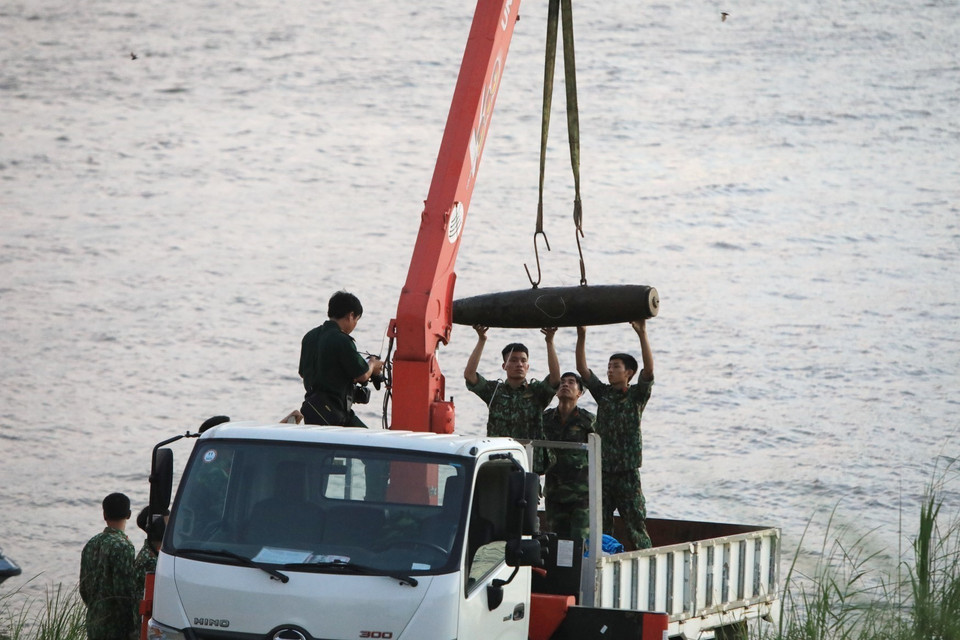 Lực lượng chức năng tiến hành trục vớt quả bom chưa nổ dưới sông Hồng, cách chân cầu Long Biên về phía thượng lưu khoảng 600m. Quả bom dài 1,6m, có đường kính khoảng 35cm, nằm sâu 2m. (Ảnh: Thành Đạt/TTXVN)