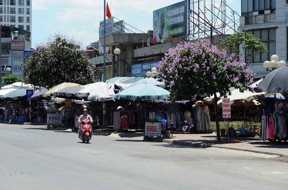 Tại khu vực đường Nguyễn Trãi có rất nhiều quầy hàng tự phát bày bán các loại quần áo, khẩu trang chống nắng để phục vụ người dân. (Ảnh: Quang Quyết/TTXVN) 