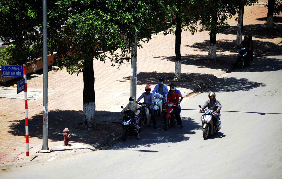 Người dân tại Hà Nội tranh thủ nghỉ ngơi dưới những gốc cây, gầm cầu vượt để tránh nắng nóng. (Ảnh: Quang Quyết/TTXVN) 