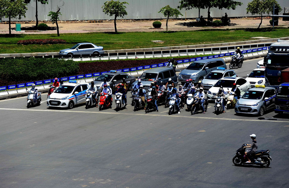 Mặc dù phải chịu nắng nóng nhưng người dân vẫn chấp hành nghiêm túc tín hiệu đèn báo khi tham gia giao thông. )Ảnh: Quang Quyết/TTXVN) 