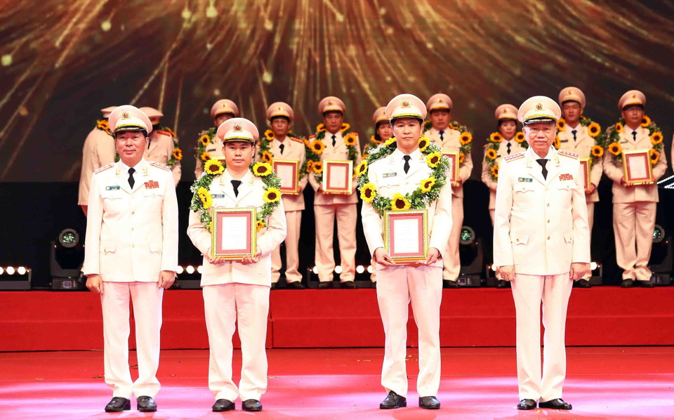 Đại tướng Tô Lâm, Bộ trưởng Bộ Công an và Thượng tướng Trần Quốc Tỏ, Thứ trưởng Bộ Công an tuyên dương các điển hình tiên tiến trong học tập, thực hiện Sáu điều Bác Hồ dạy. (Ảnh: Phạm Kiên/TTXVN)