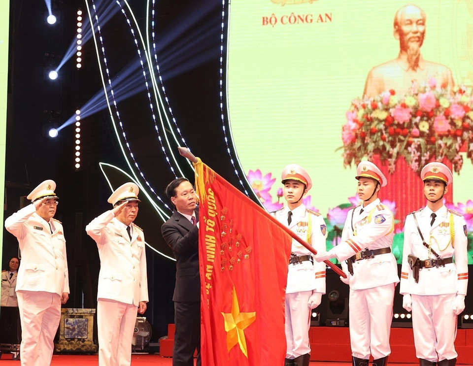 Chủ tịch nước Võ Văn Thưởng gắn Huân chương Bảo vệ Tổ quốc hạng Nhất lên lá cờ truyền thống Xây dựng lực lượng công an nhân dân. (Ảnh: Trí Dũng/TTXVN)