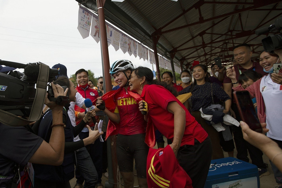 Khoảnh khắc hạnh phúc của hai mẹ con VĐV Đinh Thị Như Quỳnh khi cô về đích đầu tiên và đoạt tấm HCV cho đội tuyển xe đạp địa hình Việt Nam tại SEA Games 31. (Ảnh: Trọng Đạt/TTXVN)