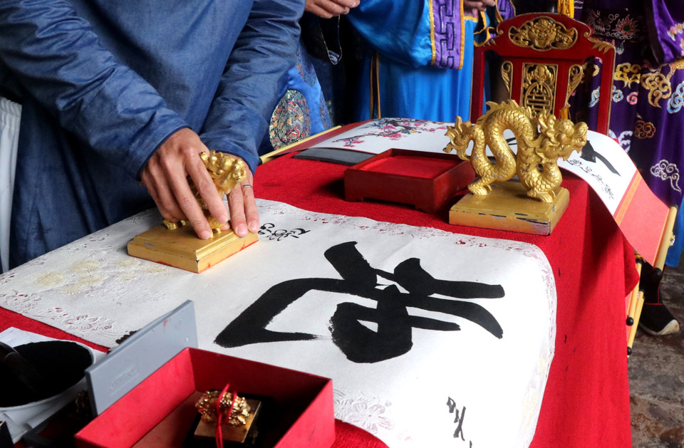 Kim ấn được đóng vào các bức thư pháp có viết những chữ: Phúc, Lộc, Thọ, Cát tường, Bình an… mang ý nghĩa may mắn tặng cho du khách. (Ảnh: Tường Vi/TTXVN)