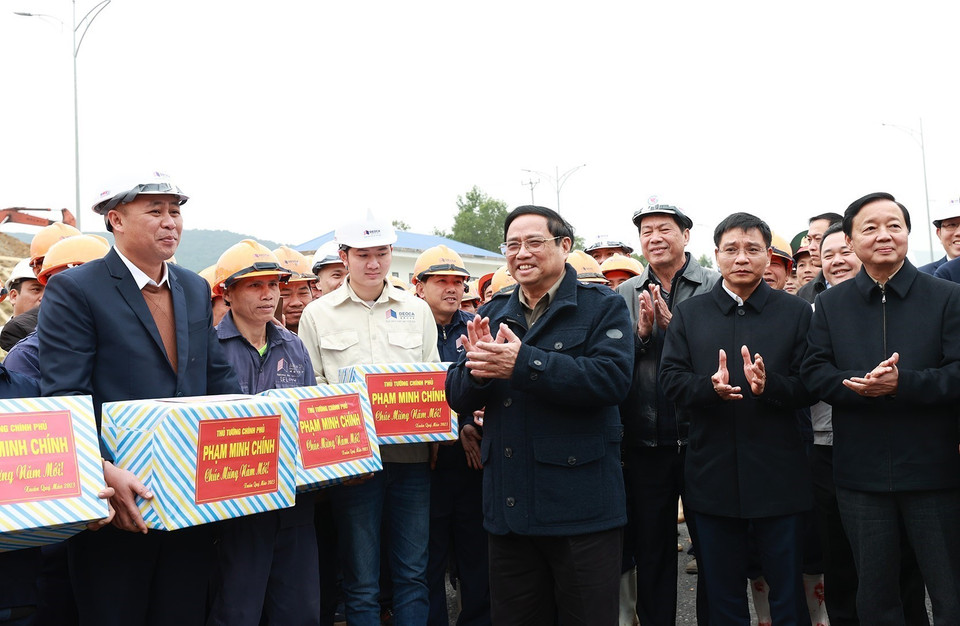Thủ tướng Phạm Minh Chính động viên, chúc mừng năm mới tới kỹ sư, công nhân thi công hầm Thung Thi. (Ảnh: Dương Giang/TTXVN)
