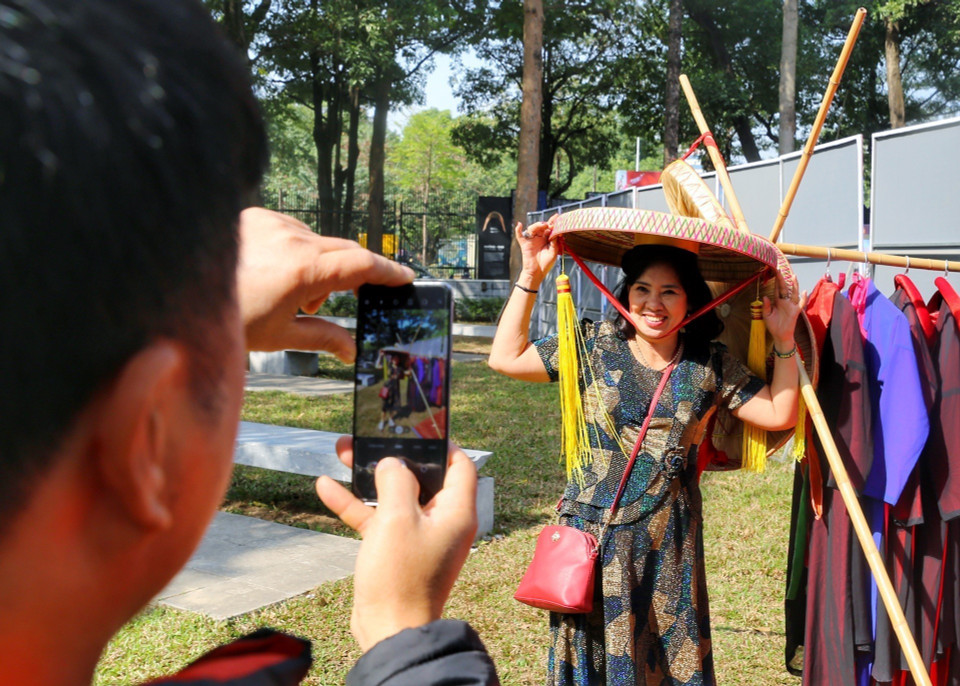 Du khách thử trang phục quan họ. (Ảnh: Tuấn Đức/TTXVN)