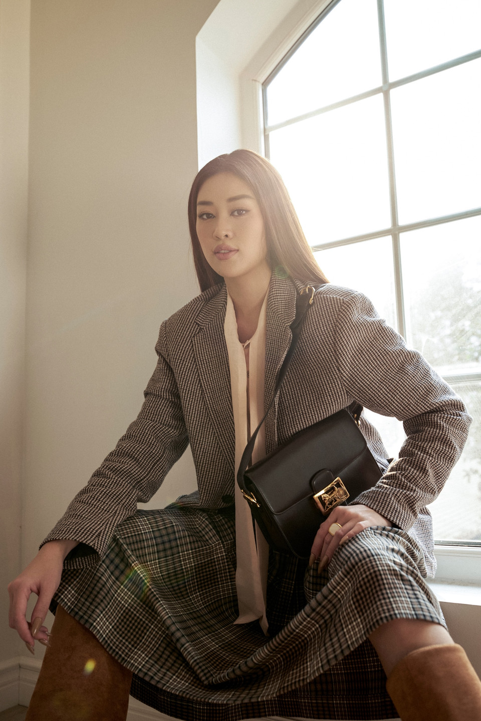 Khánh Vân chọn bộ trang phục kết hợp giữa vest caro, đầm xòe gam màu tối và đôi boot cổ cao nhằm nhấn mạnh sự đối lập, đấu tranh nội tâm, dung hòa giữa cá tính mạnh mẽ và vẻ ngoài ngọt ngào, tình cảm. (Ảnh: CTV/Vietnam+)