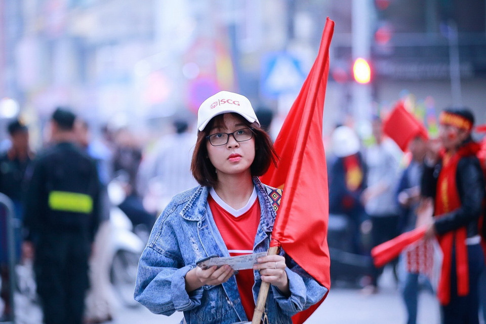 Một cổ động viên nữ mang theo cờ chuẩn bị vào sân vận động Hàng Đẫy cổ vũ cho đội tuyển Việt Nam. (Ảnh: Trọng Đạt/TTXVN)