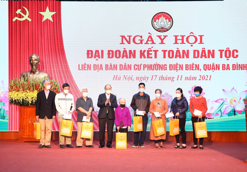 Chủ tịch nước Nguyễn Xuân Phúc trao tặng quà cho 8 hộ gia đình có hoàn cảnh khó khăn tại phường Điện Biên, quận Ba Đình. (Ảnh: Phạm Kiên/TTXVN)
