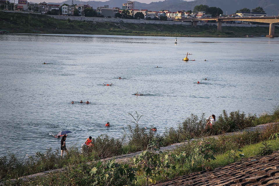  Người lớn lẫn trẻ em xuống tắm sông Đà trong những ngày nắng nóng, phớt lờ những biển cấm, cảnh báo nguy hiểm. (Ảnh: Trọng Đạt/TTXVN)