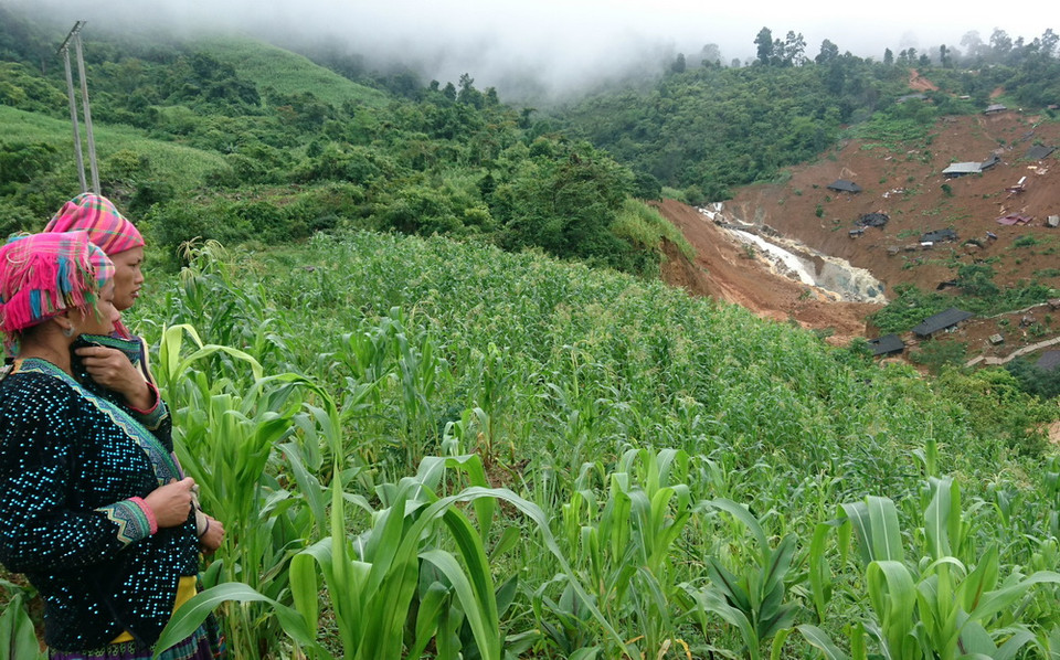 Người dân bản Sáng Tùng, xã Tả Ngảo xót xa nhìn nhà cửa, tài sản bị đất đá vùi lấp.(Ảnh: Việt Hoàng-Công Tuyên/TTXVN)