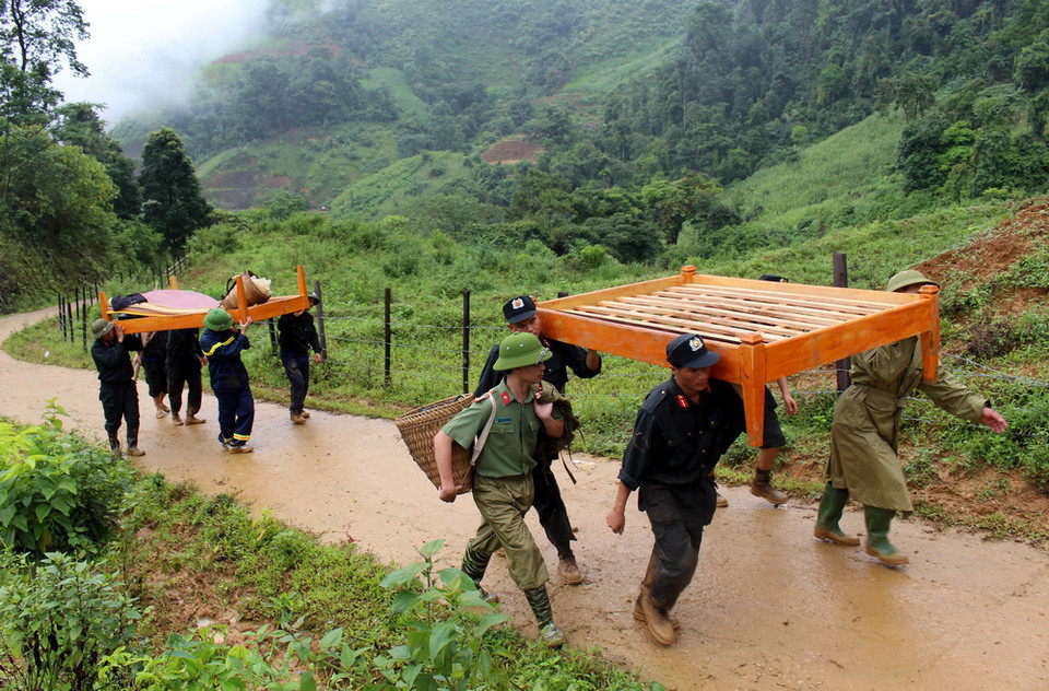 Lực lượng chức năng tích cực giúp người dân Sáng Tùng di dời đồ đạc còn lại đến nơi dựng lán tạm để ở. (Ảnh: Việt Hoàng-Công Tuyên/TTXVN)