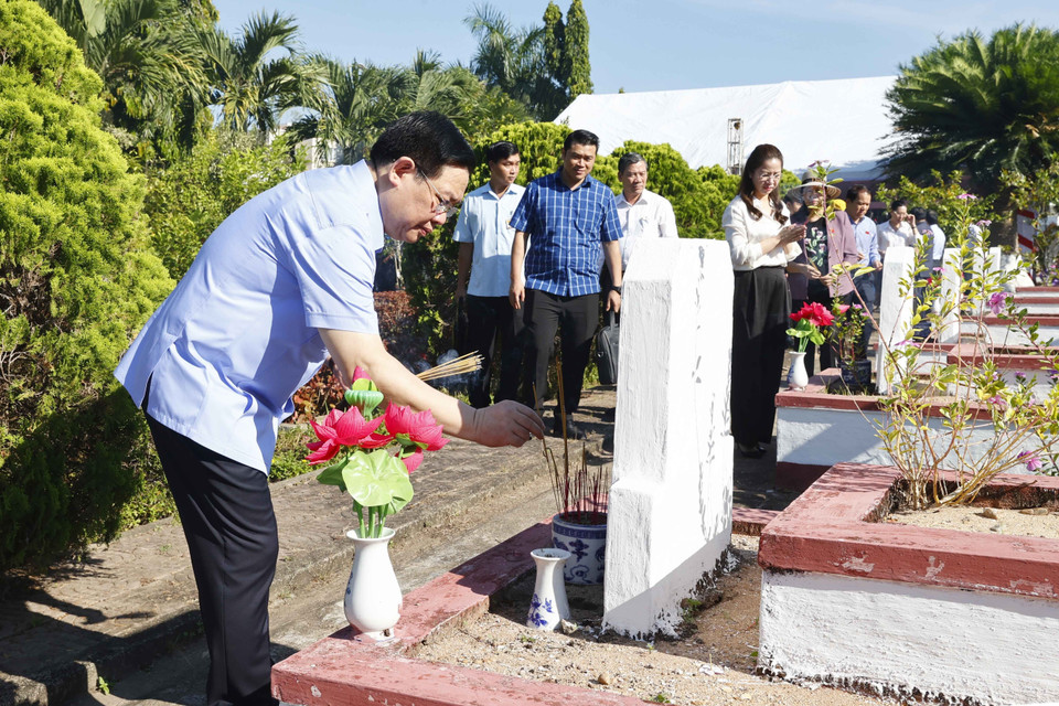 Chủ tịch Quốc hội Vương Đình Huệ thắp hương tại mộ phần của các liệt sỹ. (Ảnh: Doãn Tấn/TTXVN)