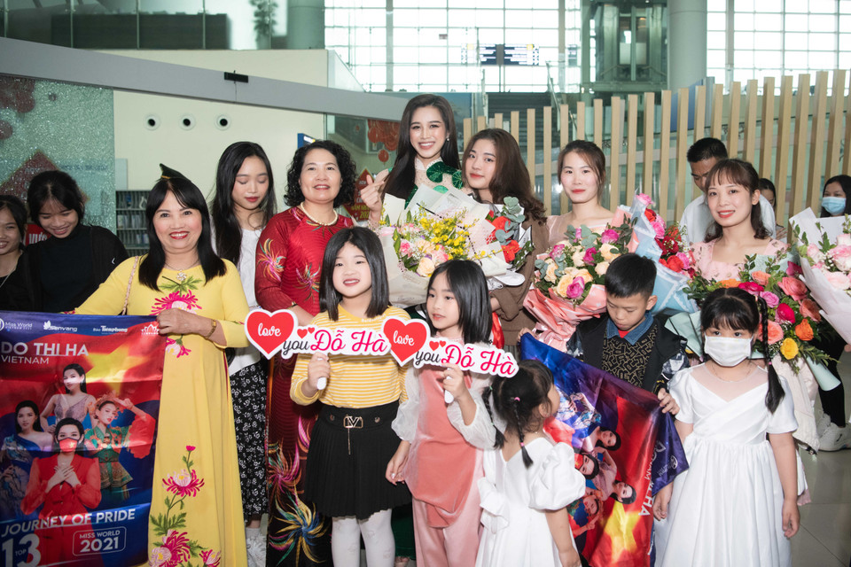 Hôm qua (ngày 28/3), dù trời mưa nhưng rất đông người thân, bạn bè cũng như người hâm mộ đã có mặt tại sân bay Thọ Xuân để đón Hoa hậu Đỗ Thị Hà trở về quê nhà. Xuất hiện tại sân bay, nàng hậu sinh năm 2001 diện bộ áo dài với họa tiết rau má độc đáo - loại rau đặc trưng quê hương cô. Đây cũng là trang phục được cô diện tại Miss World 2021 trước đây. (Ảnh: CTV/Vietnam+)