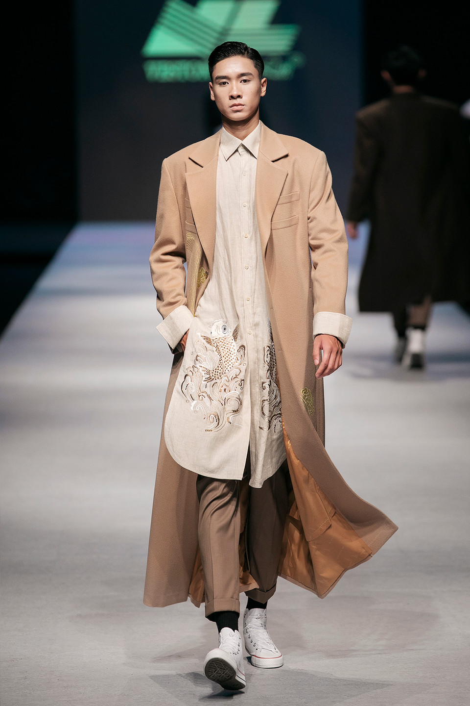 Người mẫu Hoàng Minh Tùng đảm nhận vị trí mở màn với bộ âu phục màu ghi sáng, họa tiết thêu tinh tế cùng phong thái lịch lãm, nam tính và trẻ trung. 