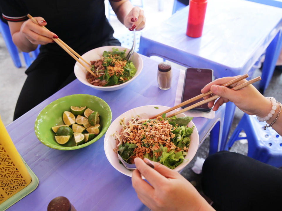 Người ăn dùng đũa và thìa để thưởng thức món Bún bò, có thể dùng thêm một số gia vị như: chanh, ớt... (Ảnh: Lâm Khánh/TTXVN)